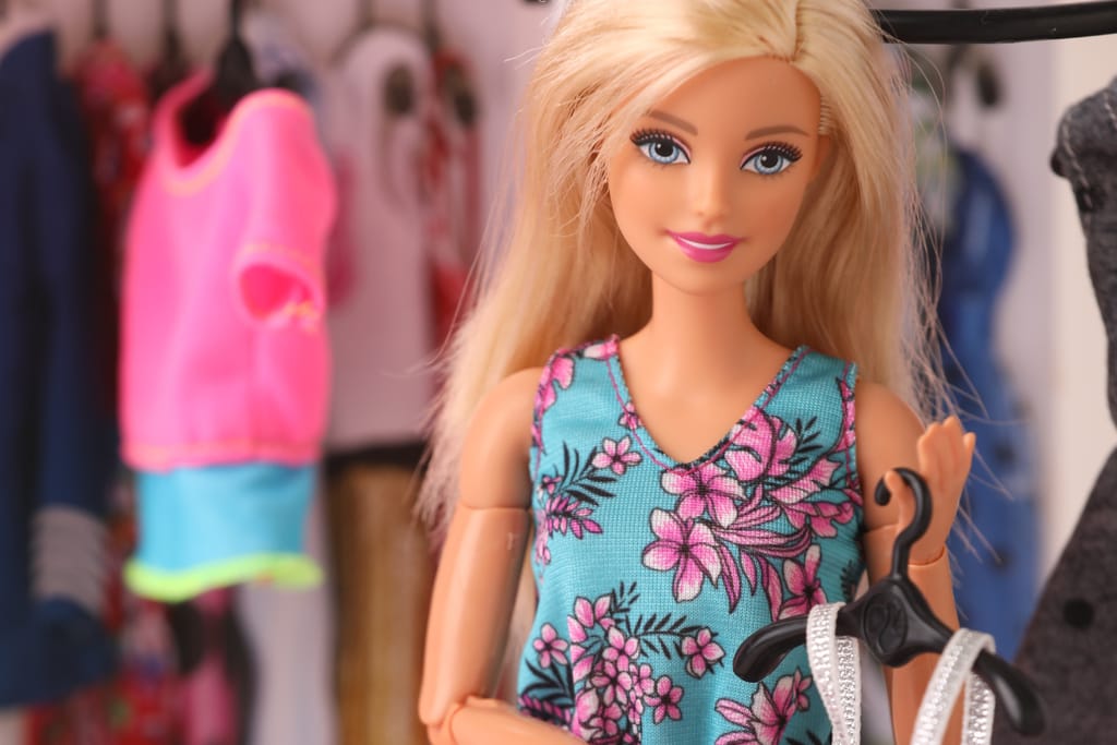 Barbie-nukke valitsee vaatteita vaatekaapissa.