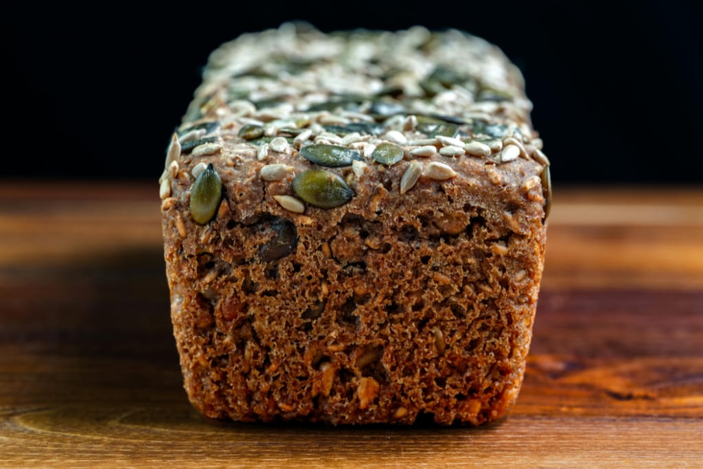 Siemenillä päällystetty tumma leipä kuvattuna lähietäisyydeltä.