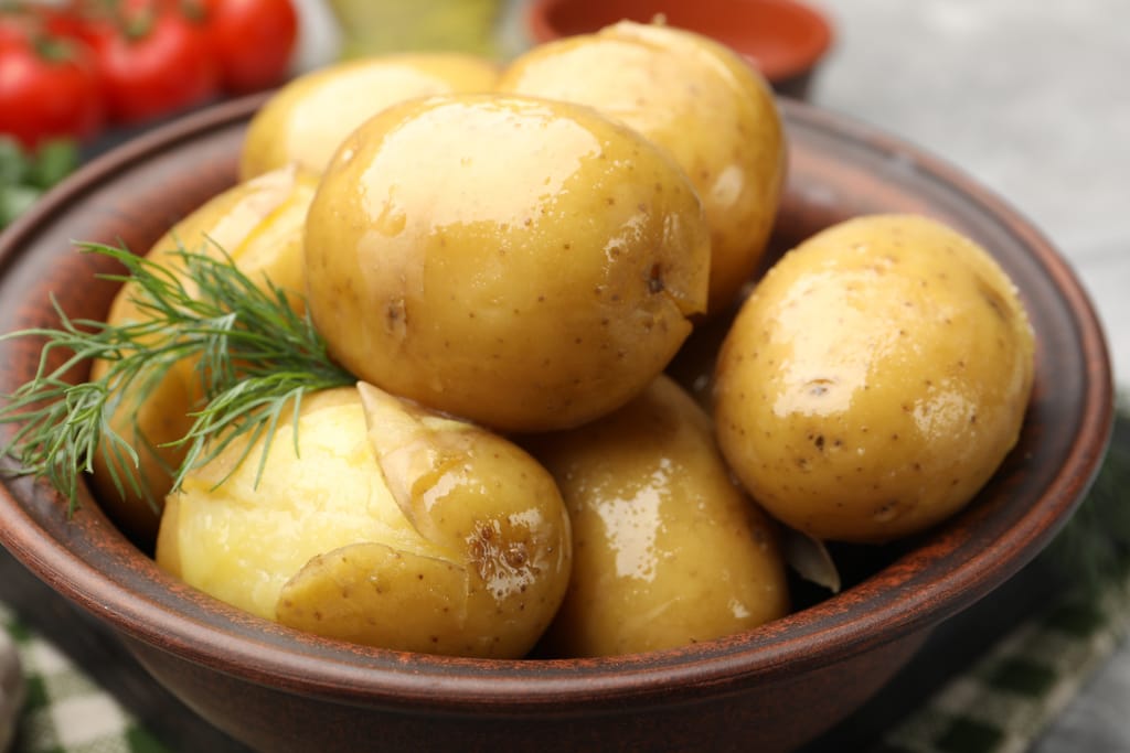 Keitettyjä perunoita kulhossa, päällä tilliä.