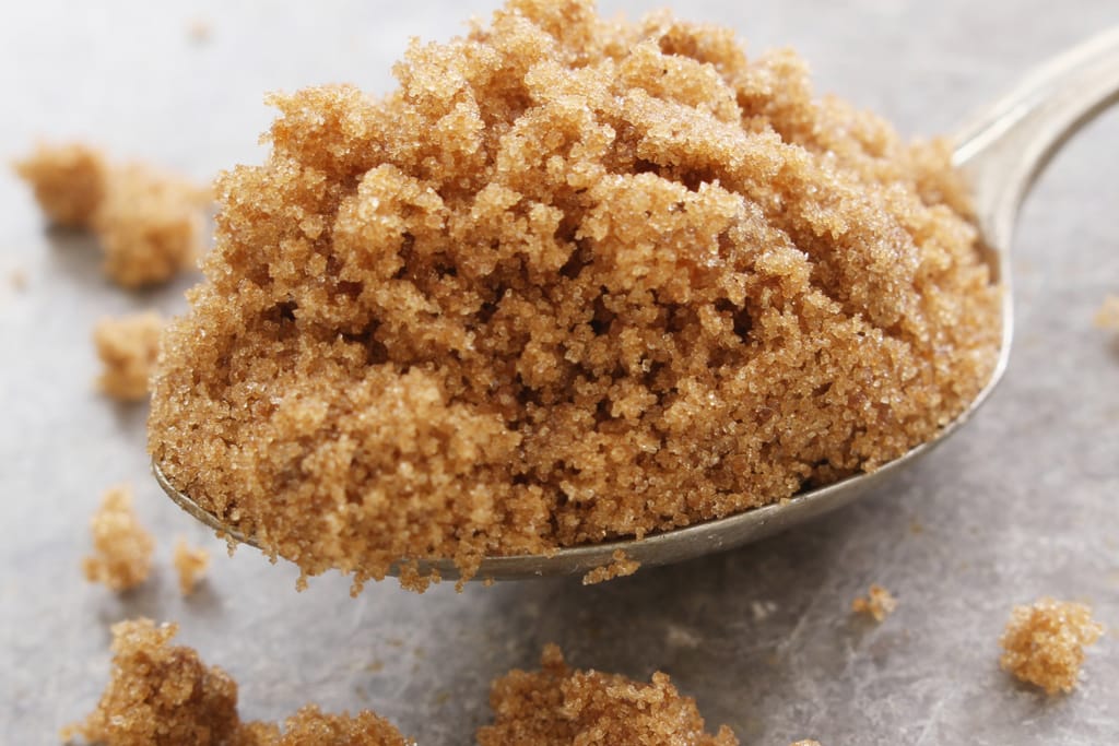 Lusikallinen fariinisokeria lähikuvassa vaaleaa taustaa vasten.