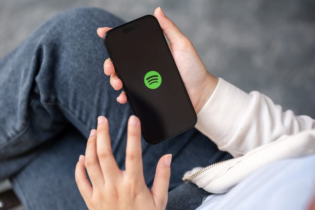 Henkilö käyttää Spotify-sovellusta älypuhelimella