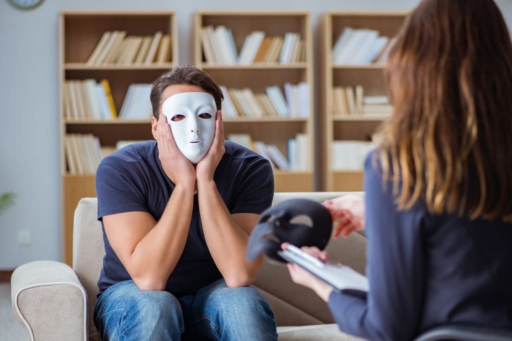 Henkilö valkoinen naamio kasvoilla keskustelee toisen kanssa