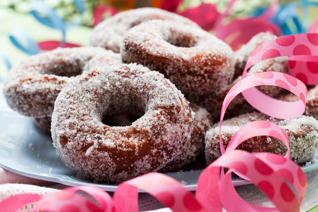 Munkkeja pöydällä lautasella. Vieressä serpentiiniä.