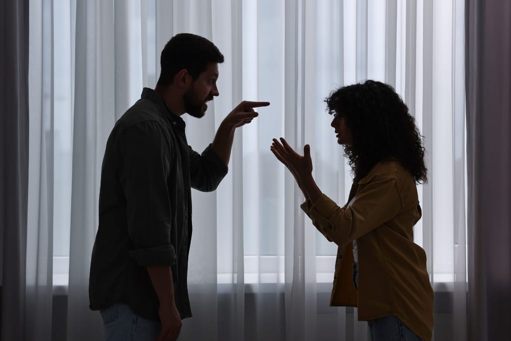 Mies ja nainen riitelevät ja elehtivät voimakkaasti toisiaan kohti.