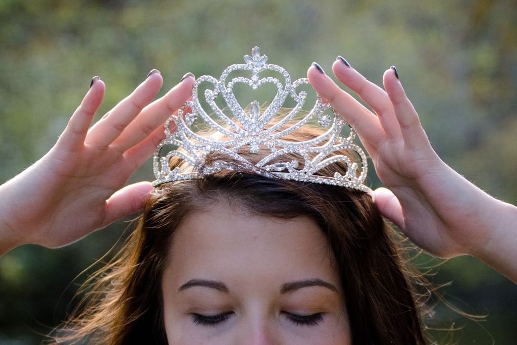 nainen asettaa kruunua päähän symboloiden korkeita deittailustandardeja