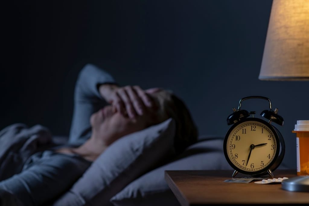 ahdistus illalla unettomuus yöllä henkilö hereillä sängyssä stressi