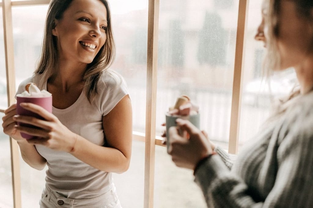 Kaksi naista keskustelee kahvin äärellä – syvempi yhteys syntyy avoimuudesta ja kuuntelemisesta