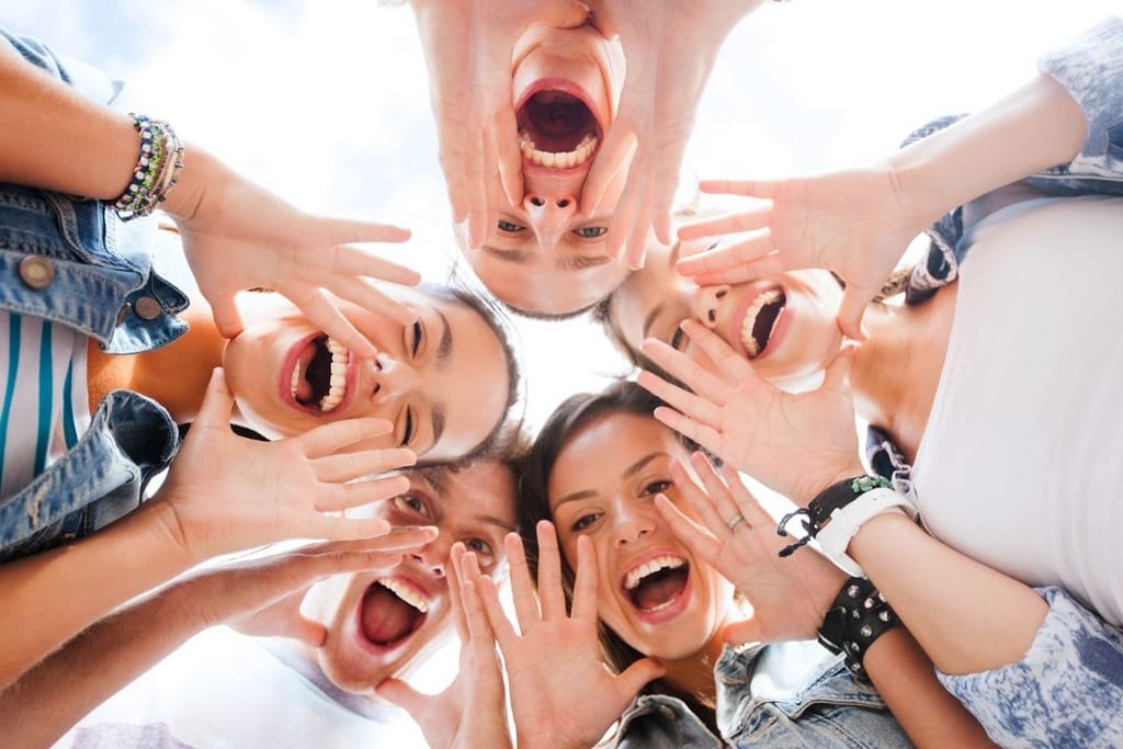 iloinen kaveriporukka nauramassa yhdessä kesäpäivänä läheisessä ystävyydessä