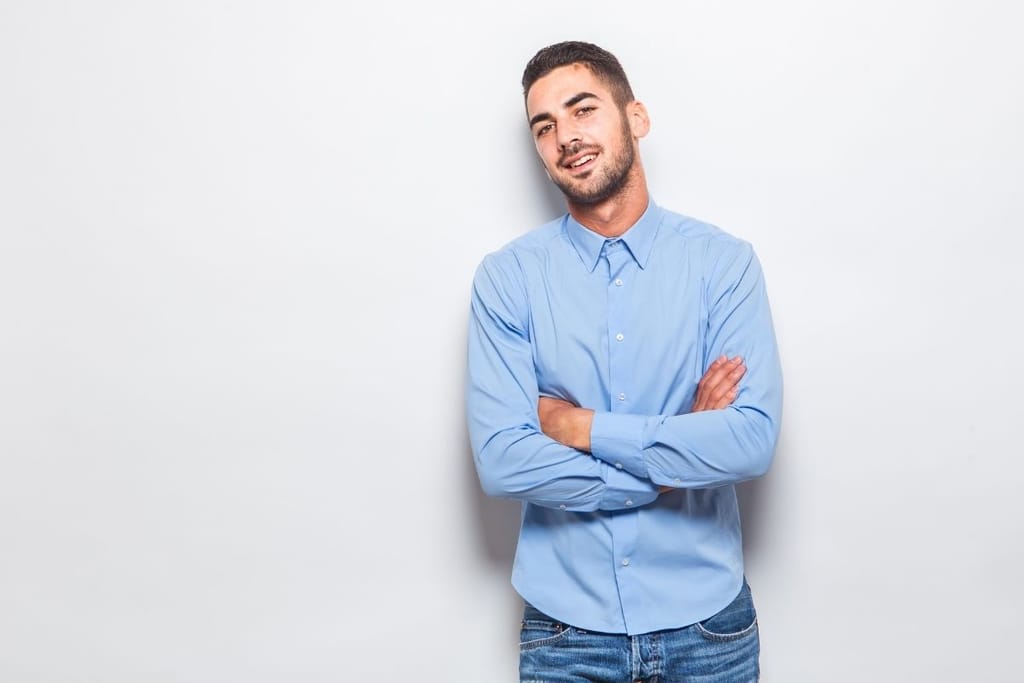 itsevarma mies seisoo kädet ristissä ja viihtyy sinkkuna