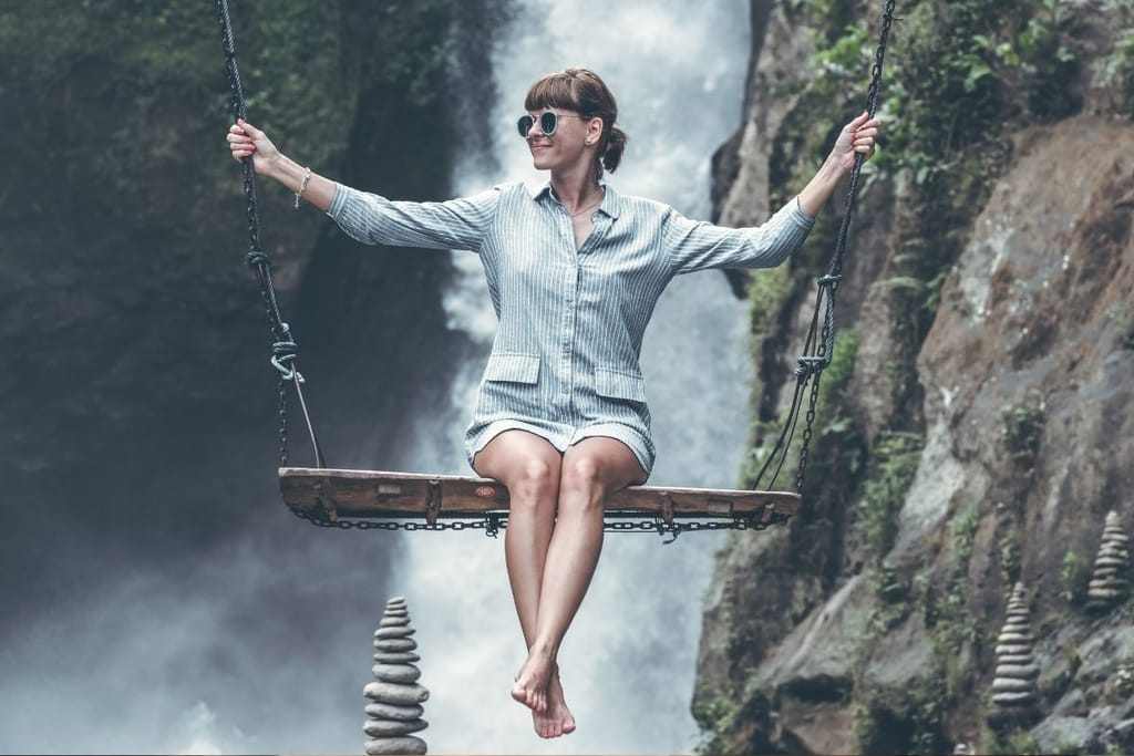 Itsenäinen nainen keinussa luonnossa – sinkkuelämä ja vapaus kuvattuna