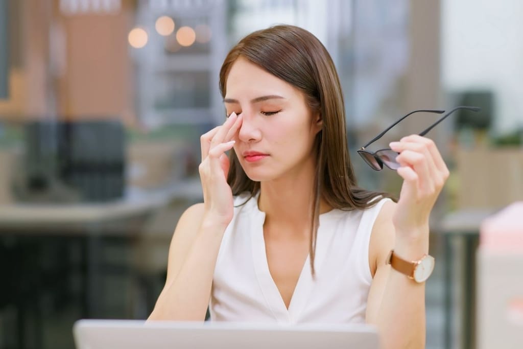 Nuori työntekijä stressaantuneena tietokoneella – tekoäly ja työpaineet kuormittavat työelämässä