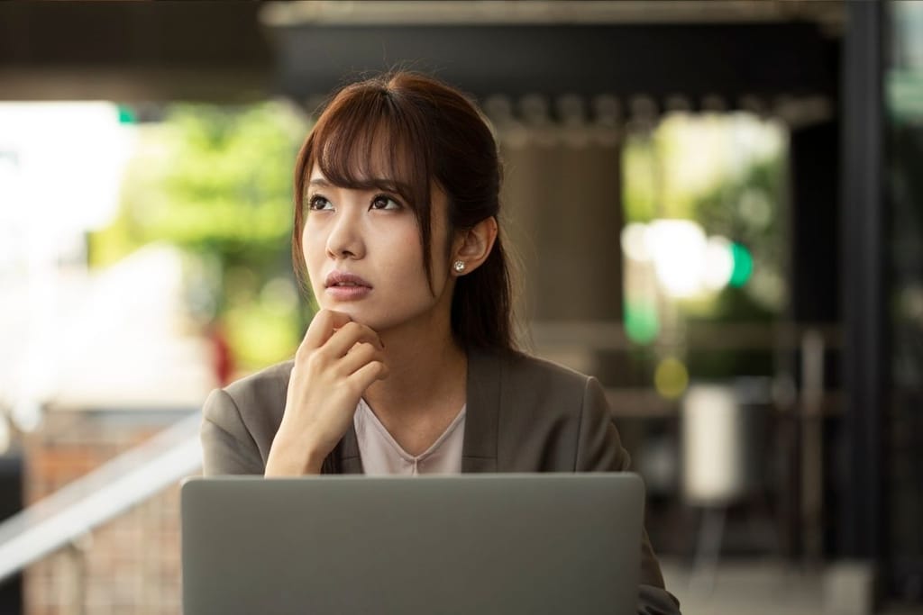 työelämä ura pysähtynyt nainen miettii tietokoneella toimistossa