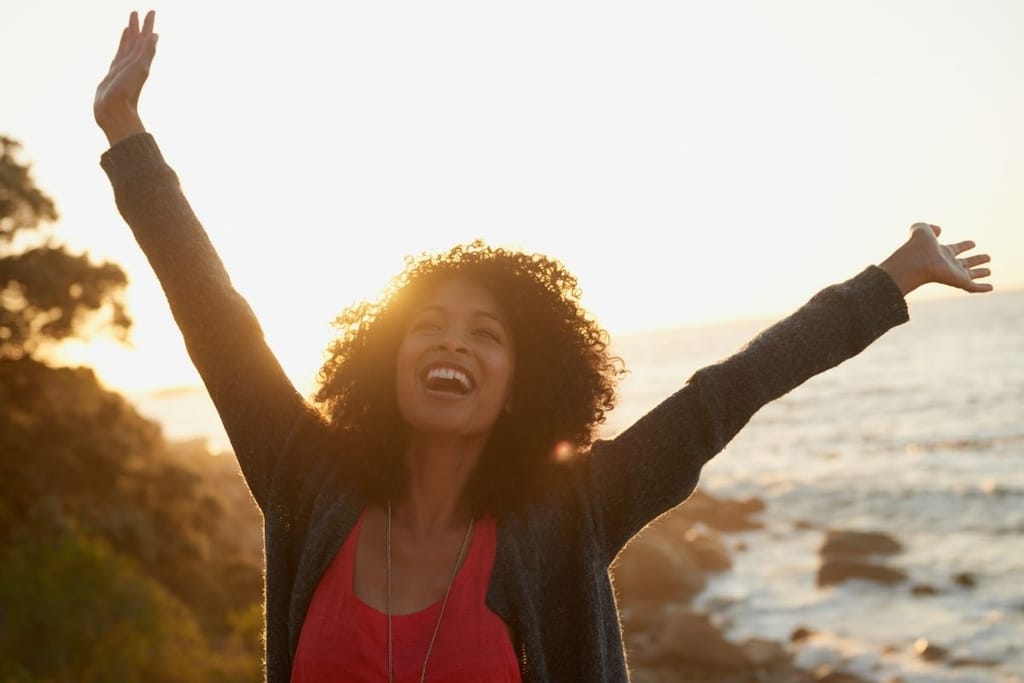 nainen nauttii yllättävästä vapaa-ajasta auringonlaskussa rannalla