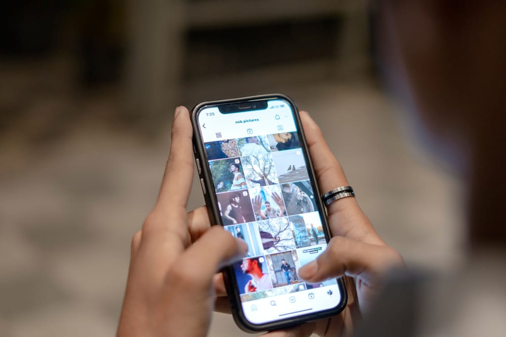 Henkilö selaa kuvia älypuhelimen näytöltä.