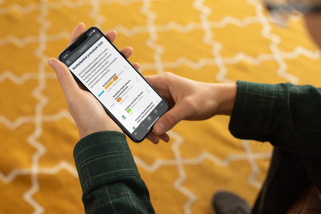Henkilö pitää puhelinta ja salaa avoimia työpaikkoja.