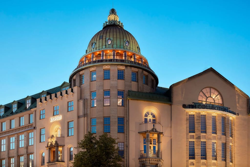 Kupolikattoinen historiallinen rakennus iltavalaistuksessa kaupungissa.