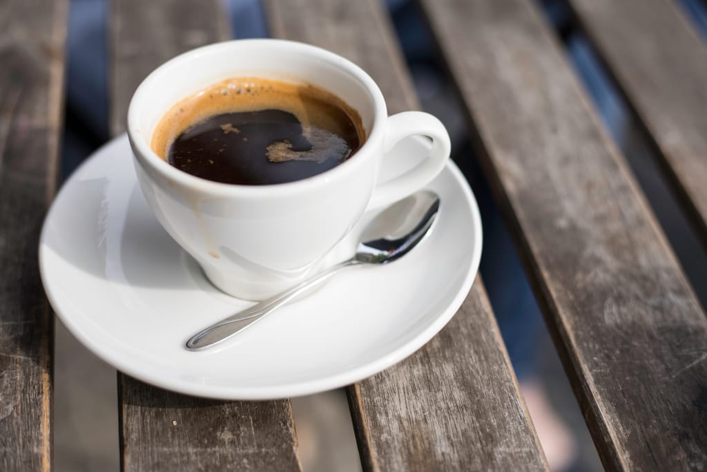 Kupillinen mustaa kahvia terassipöydällä.