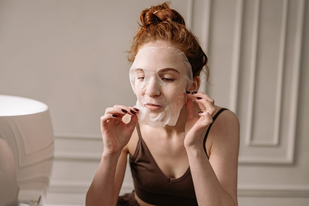 Nainen laittaa kasvonaamiota.