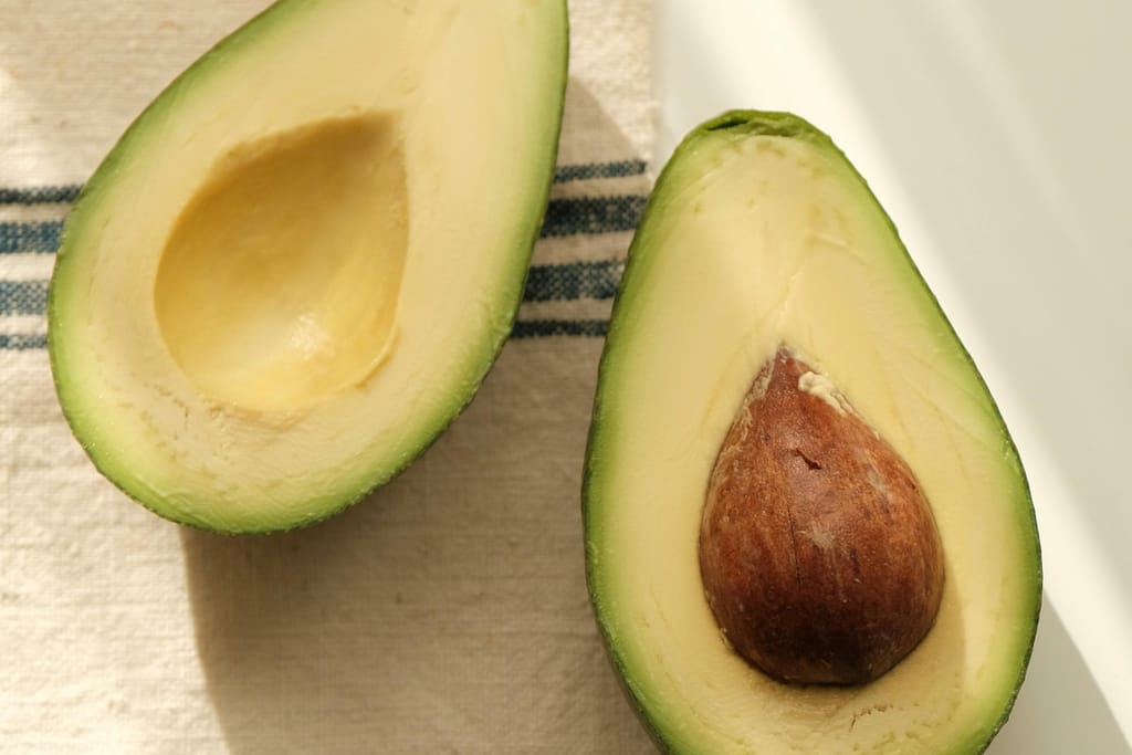 Avokado halkaistuna liinan päällä pöydällä.