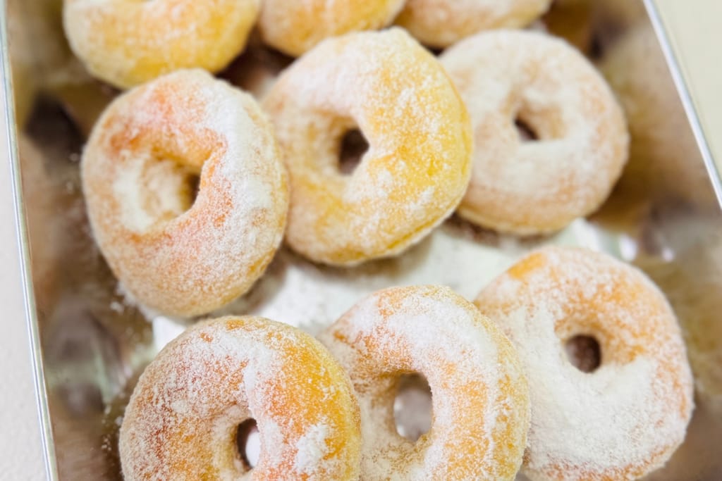 Sokerikuorrutettuja donitseja rivissä.