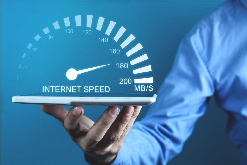 Internetin nopeusmittari kelluu sinitaustaisen tabletin yllä – mittari osoittaa noin 180 megabittiä sekunnissa.