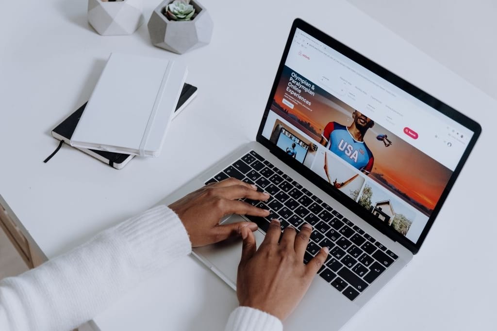 Matkailija selaa Airbnb-ilmoituksia kannettavalla tietokoneella — Airbnb-arvostelujen varoitusmerkit jäävät usein huomaamatta