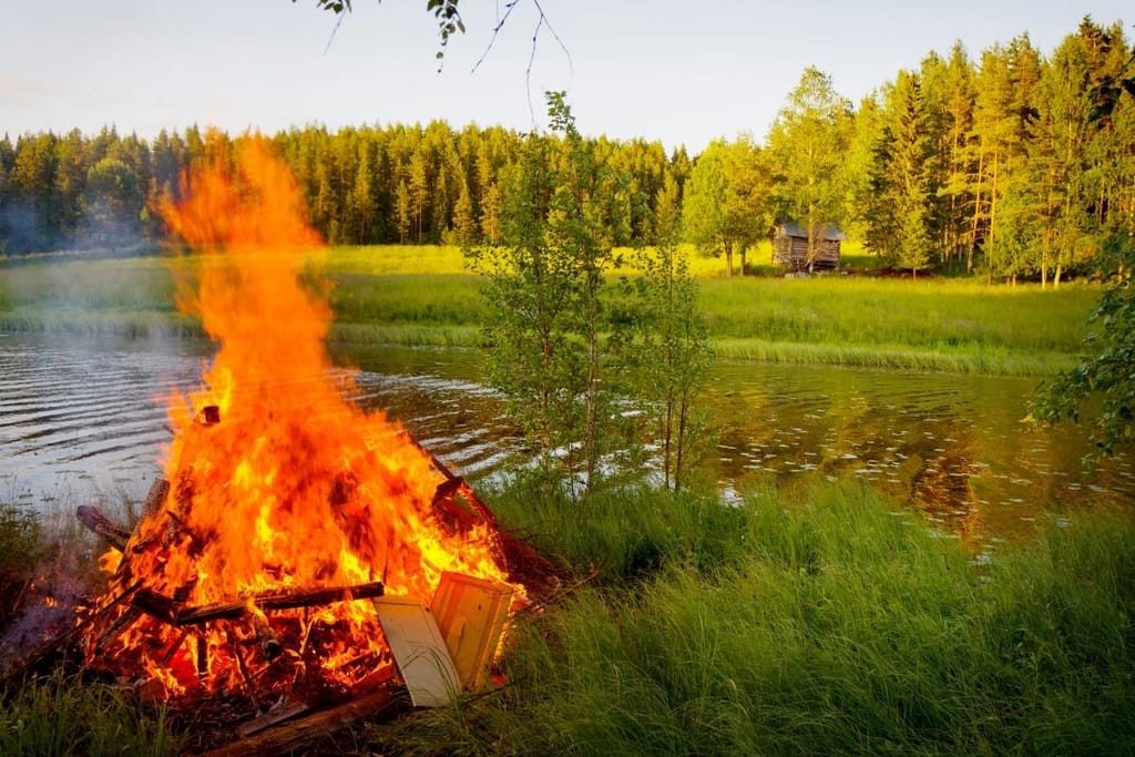 Juhannuskokko palaa järven rannalla kesäillassa