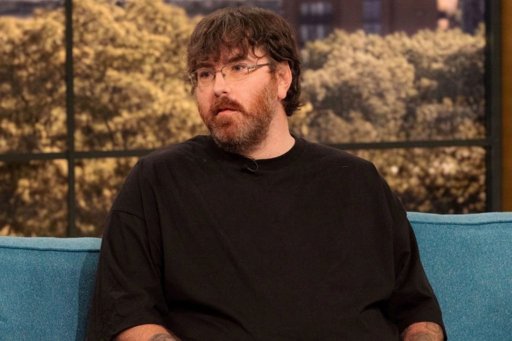 Michael Phillips istuu televisio-ohjelman sohvalla mustat lasit päässä