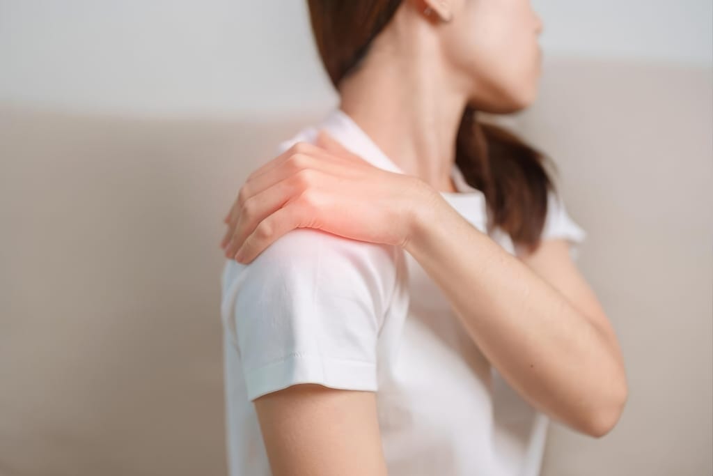 Fibromyalgiaa sairastava henkilö pitelee kipeää olkapäätään