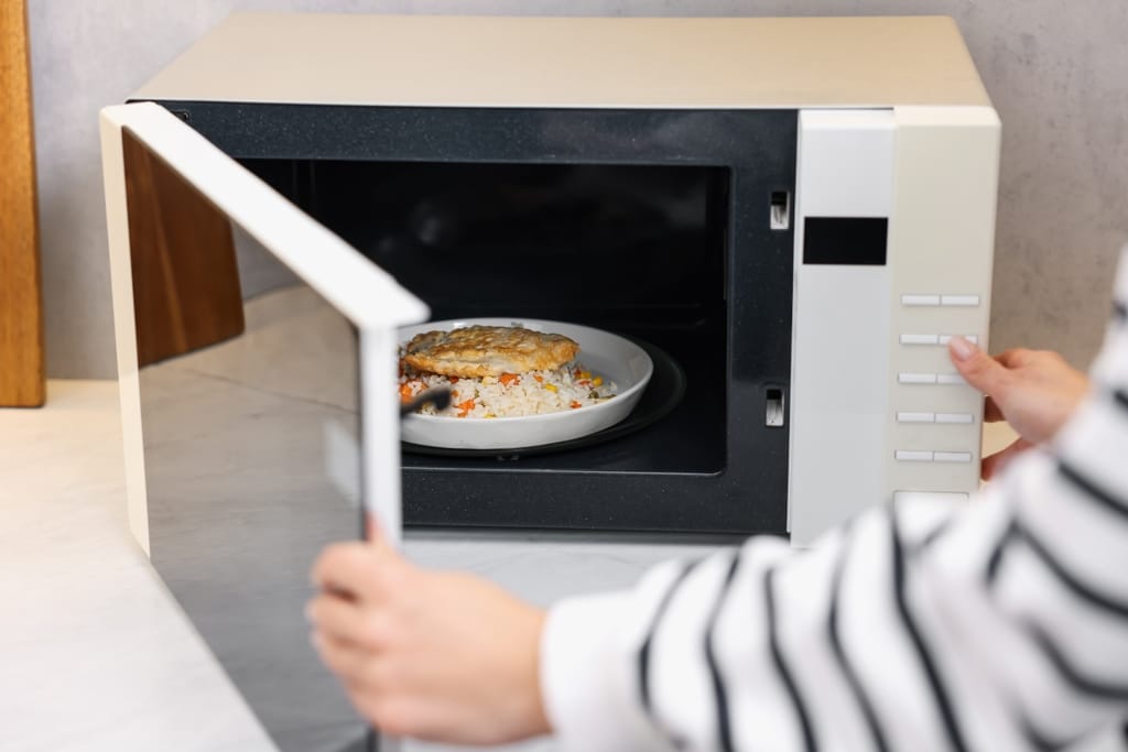 Ruokalautanen mikroaaltouunin pyörivällä alustalla ennen lämmittämistä