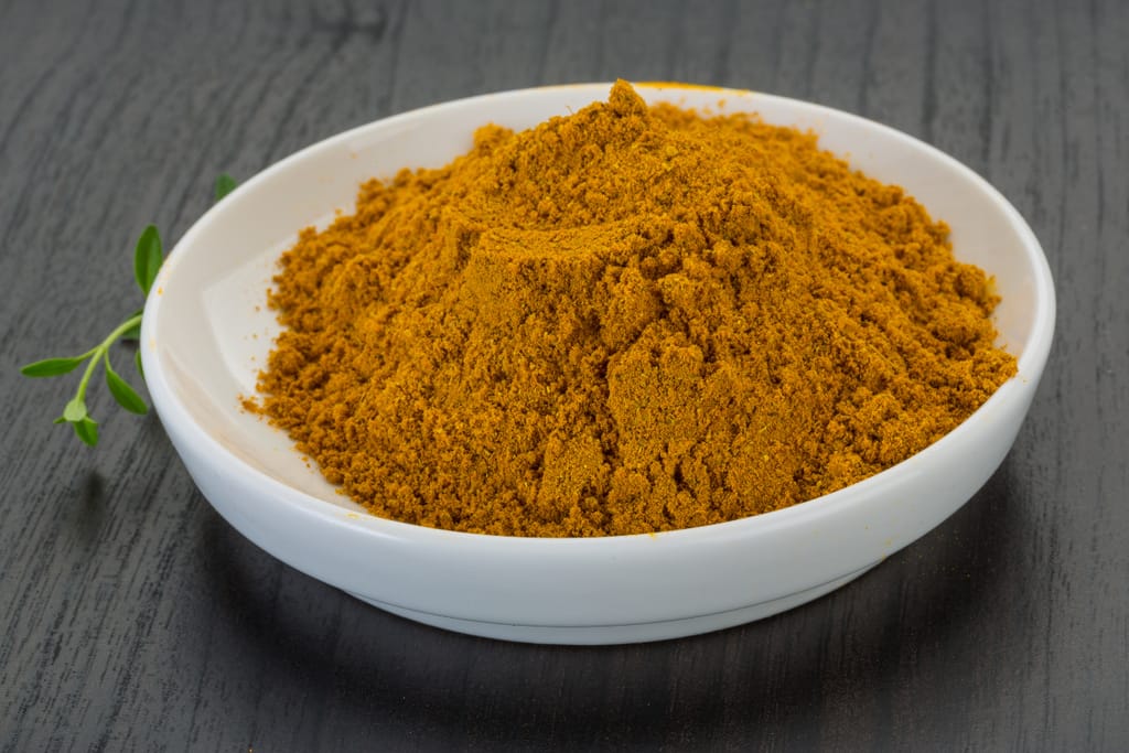 Pieni kulho, jossa curry-maustetta.