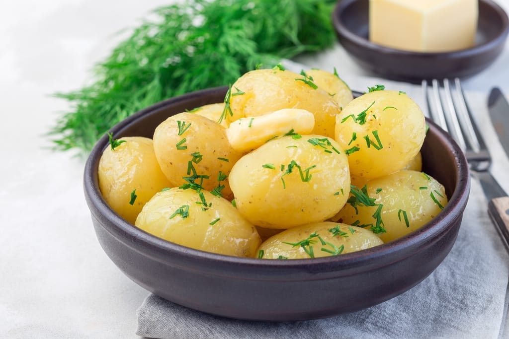 Kulhollinen keitettyjä perunoita tillin ja voin kanssa.
