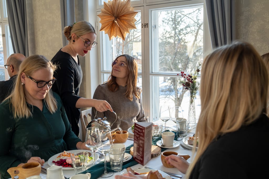 Ravintola Backaksen brunssipöytä, jossa henkilöitä syömässä.