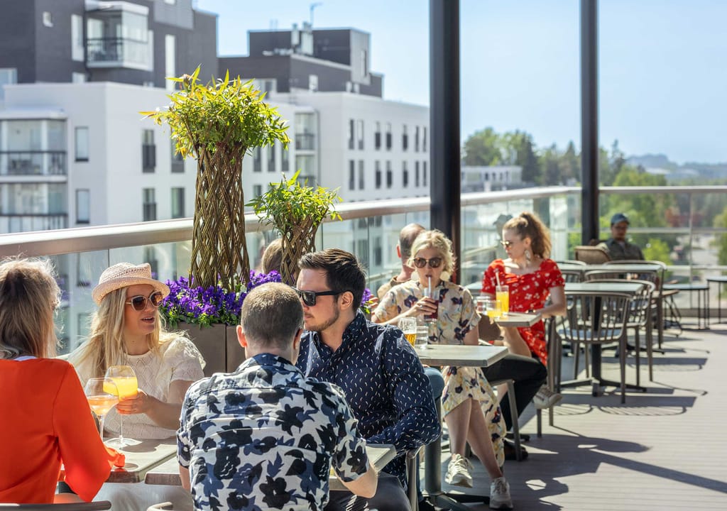 Freja Rooftopin terassilla ihmiisä. Taustalla kaupunkimaisema.