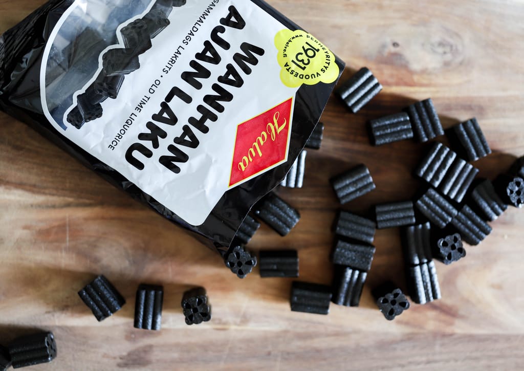 Halvan lakritsipussi avoinna pöydällä lakritsia.
