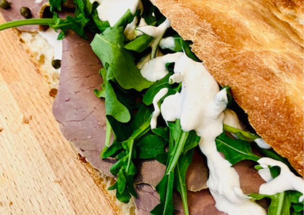 Fine dining -annos pöydällä: kulhossa suolattua raaka-ainetta, kastike ja juuresviipaleita.