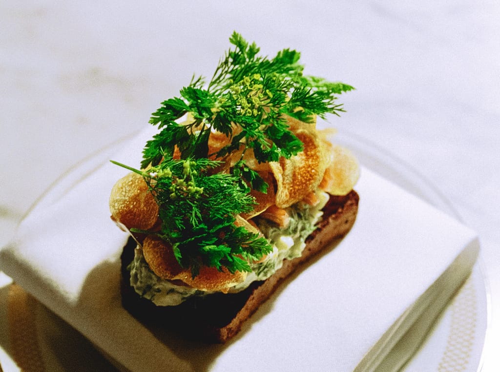 Ravintola 305:n annos lautasliinalla, jonka päällä tuoreita yrttejä.