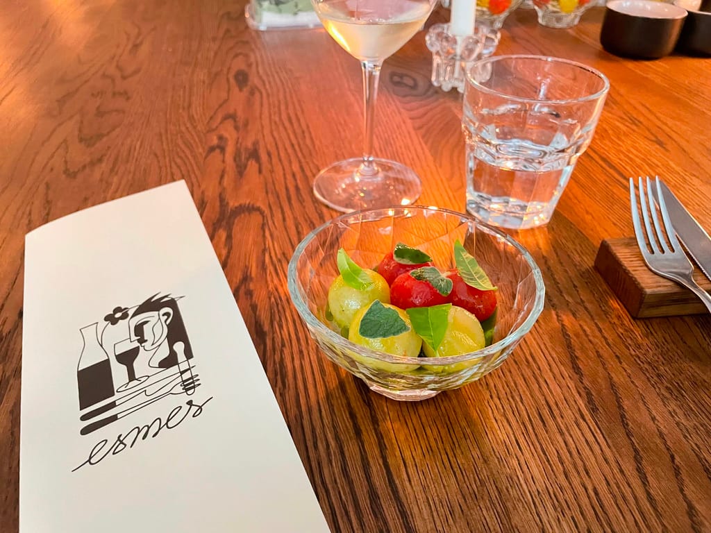 Ravintola Esmeksen annos, jossa kirsikkatomaattia. Ruokalista vieressä.