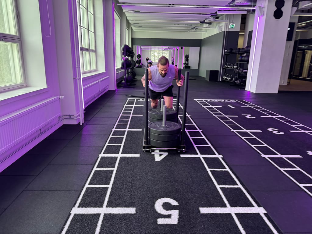 Janne Lehtonen työntää kelkkaa Hyrox-salilla.