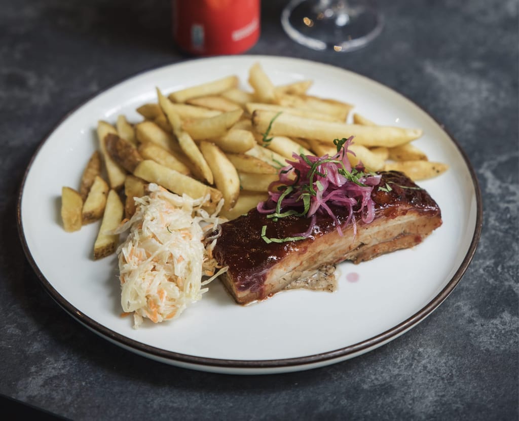 Roka Street Bistron annos, jossa porsaanlihaa, perunoita ja coleslaw-salaattia.