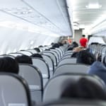 Lentokoneen matkustamo täynnä ihmisiä.