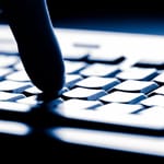 Sormi painaa näppäimistöä pimeässä – CSAM-ilmiö liittyy verkossa tapahtuvaan rikolliseen toimintaan