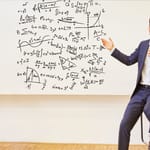 Yritysjohtaja esittelee monimutkaisia kaavoja – kuva havainnollistaa yritysjargonin monimutkaisuutta työelämässä