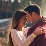 Onnellinen pariskunta päät toisiaan vasten ilta-auringossa.