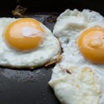 Kaksi paistettua kananmunaa pannulla.