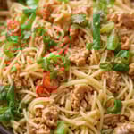 Pannulla valmistettu perunapohjainen nuudeliruoka, jossa on kastiketta, yrttejä ja viipaloitua chiliä.