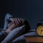 ahdistus illalla unettomuus yöllä henkilö hereillä sängyssä stressi