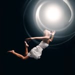 Nainen leijumassa kohti kirkasta valoa symboloimassa tietoisuuden jatkumista ja kvanttikuolemattomuutta