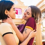 Kaksi naista halaa ja hymyilee läheisesti – nopea rakastuminen liittyy tunteiden voimakkuuteen