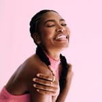 Hymyilevä nainen nauttii hetkestä – itsevarmuus ja läsnäolo lisäävät vetovoimaa